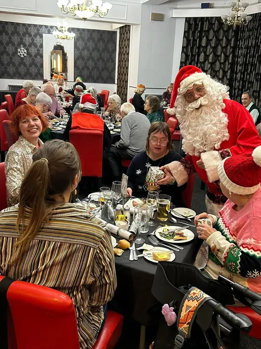 Father Christmas serving the Spiral group at their festive dinner