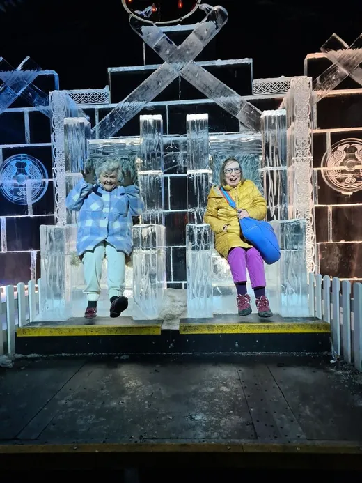 Two holidaymakers sitting on a carved ice throne at Winter Wonderland