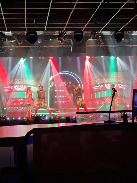 A colourful live stage show with dancers and bright lighting