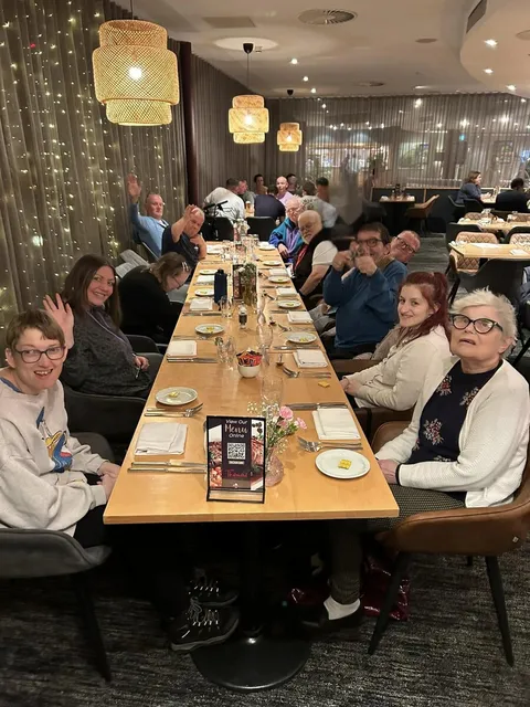 The group together around a long table for their Christmas meal