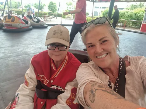 Two holidaymakers smiling together at the dodgems