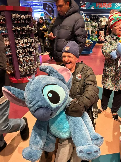 A holidaymaker holding a Stitch soft toy in one of the Disney shops