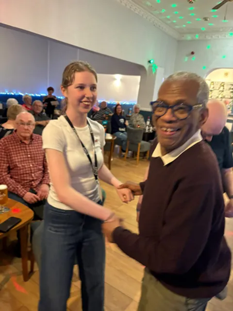 A Spiral volunteer dancing with a holidaymaker