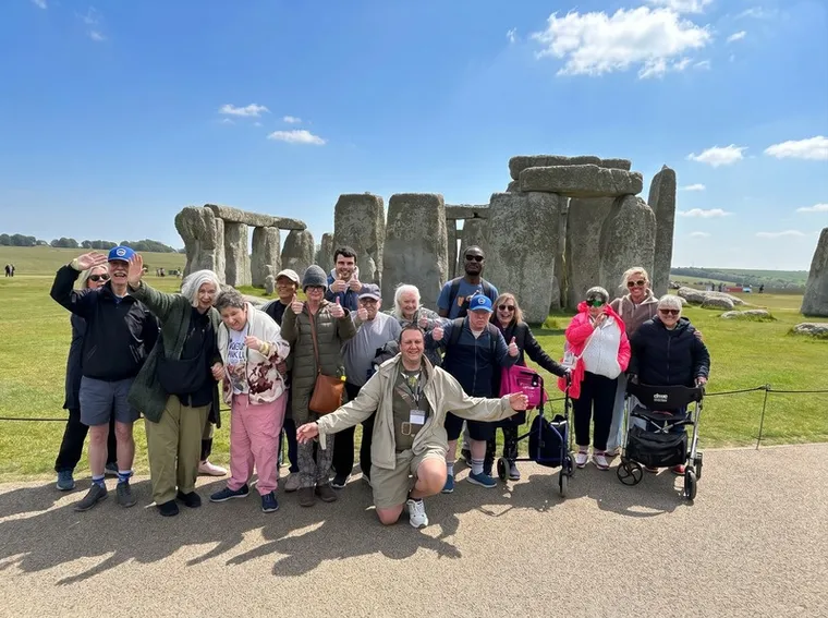 A big group of Spiral holidaymakers giving thumbs up on a day out at Stonehenge