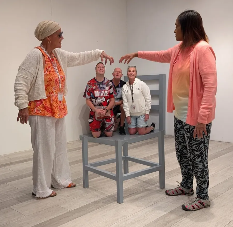 Spiral team members having fun at an optical illusion museum, pretending to shrink each other